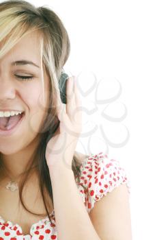 pretty casual brunette is listening to music on white background 
