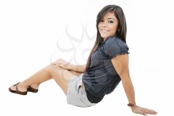 Attractive young girl sitting on the floor. All on white background.