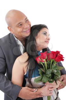 Couple holding a bouquet of red roses looking at a copyspace