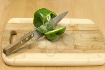 Royalty Free Photo of a Green Pepper on a Cutting Board