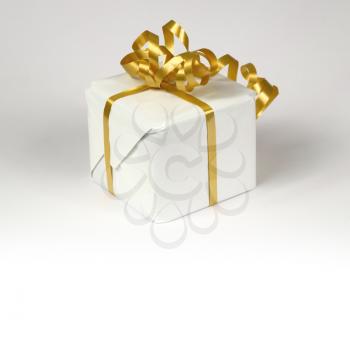White gift box with golden ribbon bow