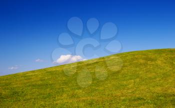 Green grass hill with clear blue sky nature background.