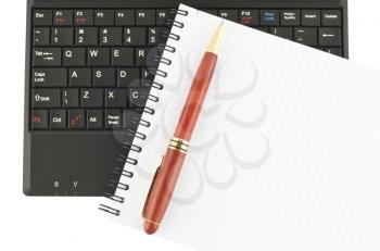 Royalty Free Photo of a Spiral Notebook With a Pen and Laptop