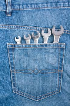 Royalty Free Photo of a Collection of Wrenches in a Denim Jean Pocket