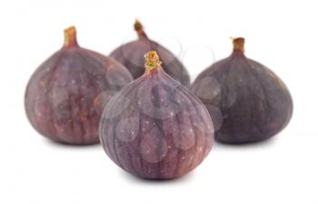 Four whole purple fig fruits isolated on white background