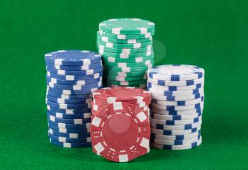 Poker chips on green playing table background