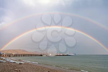Royalty Free Photo of a Double Rainbow Above a Pier