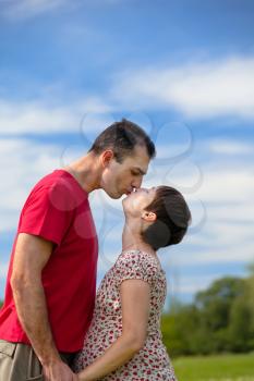 Royalty Free Photo of a Husband Kissing His Pregnant Wife