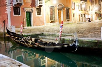 Venetian gondola at night near pier
