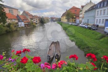 River, boats, red flowers and vintage houses in Bamberg, Germany
