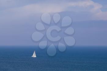 Sailing boat in open blue sea, top view
