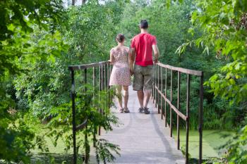 Husband with his wife on the bridge in green forest
