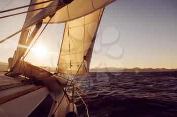 Sailboat crop during the regatta at sunset ocean, instagram toning

