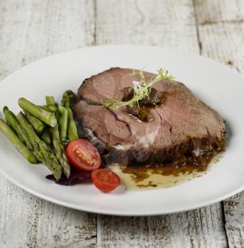 Slice Of Beef Roast With Asparagus And Tomatoes