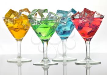 arrangement of colorful cocktails with ice cubes