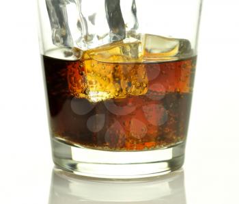 glass of cola with ice cubes close up 
