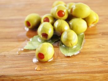 green olives on a cutting board , close up