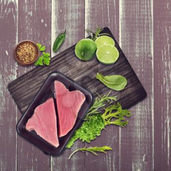Raw tuna fillet with salad leaves and limes