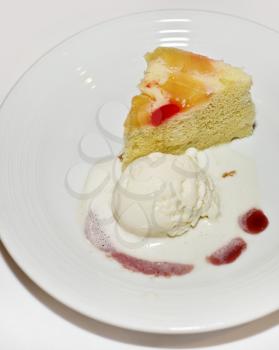 Fruit cake with vanilla ice cream on white plate