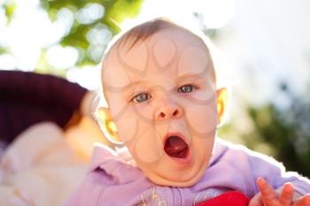 Baby girl yawns, outdoor