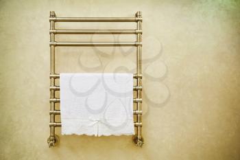 Modern heated towel rail on  bathroom wall. 