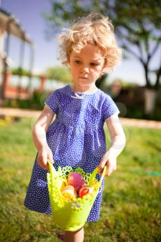 Little Girl on an Easter Egg hunt on a meadow in spring