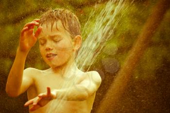 Vintage portrait of a young child playing with water