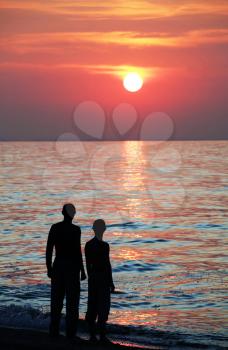 Royalty Free Photo of Two People Watching a Sunset on a Beach