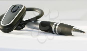 Royalty Free Photo of a Bluetooth Headset and Pen