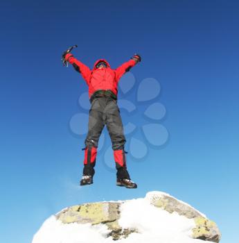 Royalty Free Photo of a Climber Jumping on a Peak