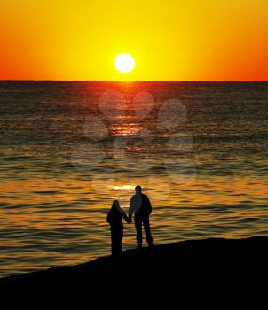 Royalty Free Photo of a Silhouette of a Couple Walking on a Beach at Sunset