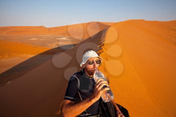 Royalty Free Photo of a Person Drinking Water in the Desert