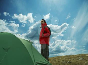 Royalty Free Photo of a Man Standing Beside a Tent