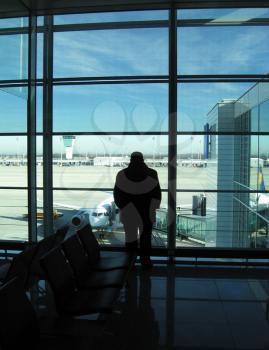 Royalty Free Photo of a Silhouette of a Man Waiting in an Airport Lounge