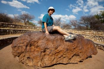Royalty Free Photo of a Tourist Sitting on the Hoba Meteorite