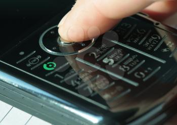 Royalty Free Photo of a Finger Pressing a Button on a Cellphone