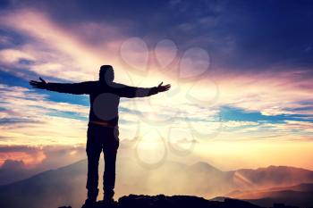 Happy Man on the sunrise in mountains. Travel and emotion concept