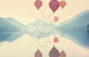 Sunrise over the mountains lake  with a air balloons above. Travel background.
