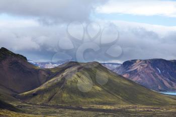 Beautiful Icelandic landscape. Green volcanic mountains in cloudy weather.
