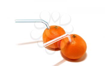 Two tangerines with straws on a white background