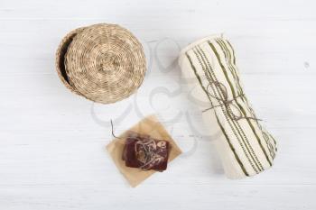 Natural soap and towel on white wooden background