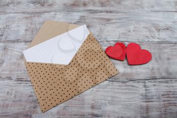 Valentine Day background with brown envelope and hearts on wood