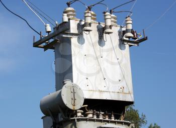 The electric transformer substation against a blue sky