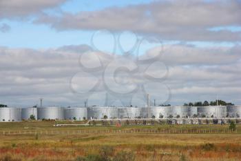 white tanks in tank farm with clouds in sky