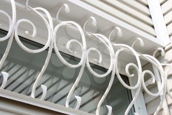 The white metal forged carved lattice at a plastic white window