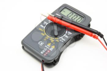 Multimeter of black color with a red and black wire on a white background