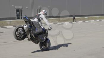 MOSCOW - MAY 15, 2018: Stunt rider making wheelie while rides on the rear wheel on May 15, 2018 in Moscow, Russia.