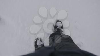 Top view of a man walking in the snow in winter.