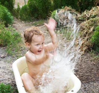 boy bathing in the tub splashing water