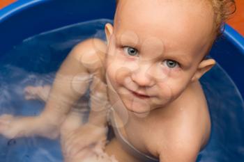 The little boy is bathed in a blue tub